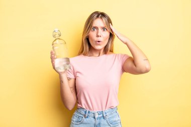 Güzel sarışın kız şaşırmış görünüyor, yeni bir düşünce, fikir ya da konsept fark ediyor. su şişesi kavramı