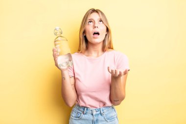 Güzel sarışın kız umutsuz, sinirli ve stresli görünüyor. su şişesi kavramı