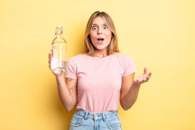 Güzel sarışın kız şok olmuş ve şaşırmış hissediyor. su şişesi kavramı