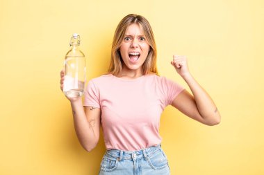 Güzel sarışın kız sinirli bir ifadeyle agresif bir şekilde bağırıyor. su şişesi kavramı