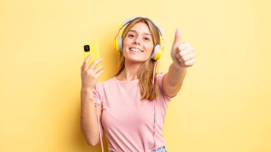 Güzel sarışın kız gururlu, olumlu gülümsüyor. müzik konseptini dinlemek