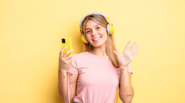 Güzel sarışın kız gülümsüyor ve arkadaş canlısı görünüyor, beş numarayı gösteriyor. müzik konseptini dinlemek