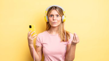 Güzel sarışın kız kapiş ya da para hareketi yapıyor, sana ödemeni söylüyor. müzik konseptini dinlemek