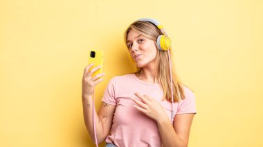 Güzel sarışın kız kibirli, başarılı, pozitif ve gururlu görünüyor. müzik konseptini dinlemek