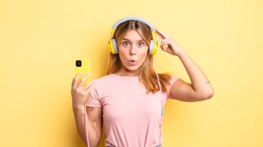 Güzel sarışın kız şaşırmış görünüyor, yeni bir düşünce, fikir ya da konsept fark ediyor. müzik konseptini dinlemek