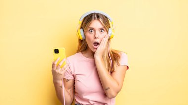 Güzel sarışın kız şok olmuş ve korkmuş hissediyor. müzik konseptini dinlemek