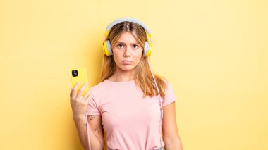 Güzel sarışın kız üzgün ve mızmızlanıyor. Mutsuz bir bakışı var ve ağlıyor. müzik konseptini dinlemek