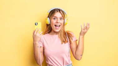 Güzel sarışın kız kendini mutlu hissediyor, bir çözüm ya da fikir bulduğuna şaşırıyor. müzik konseptini dinlemek