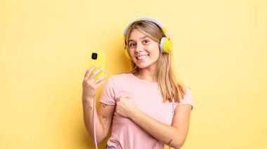 Güzel sarışın kız kendini mutlu hissediyor ve bir meydan okumayla yüzleşiyor ya da kutluyor. müzik konseptini dinlemek