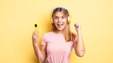 Güzel sarışın kız sinirli bir ifadeyle agresif bir şekilde bağırıyor. müzik konseptini dinlemek