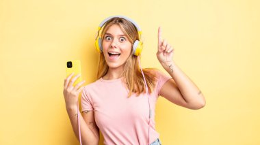 Güzel sarışın kız bir fikri fark ettikten sonra mutlu ve heyecanlı bir dahi gibi hissediyor. müzik konseptini dinlemek