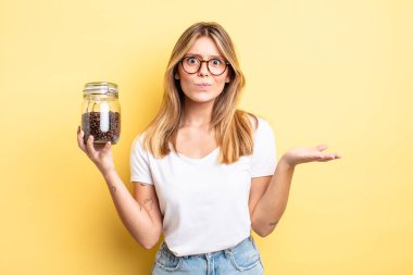 Güzel sarışın kız şaşkın, şaşkın ve şüpheci hissediyor. kahve çekirdeği konsepti