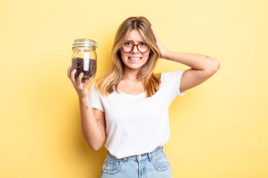 Güzel sarışın kız stresli, endişeli ya da korkmuş, elleri başının üstünde. kahve çekirdeği konsepti