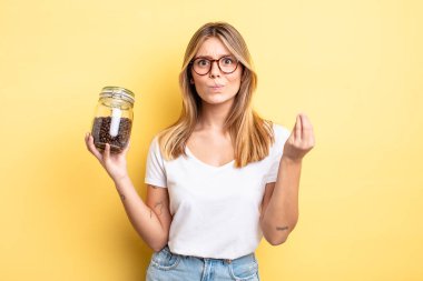 Güzel sarışın kız kapiş ya da para hareketi yapıyor, sana ödemeni söylüyor. kahve çekirdeği konsepti