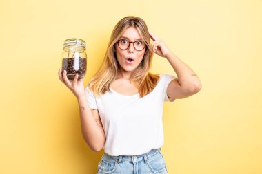 Güzel sarışın kız şaşırmış görünüyor, yeni bir düşünce, fikir ya da konsept fark ediyor. kahve çekirdeği konsepti