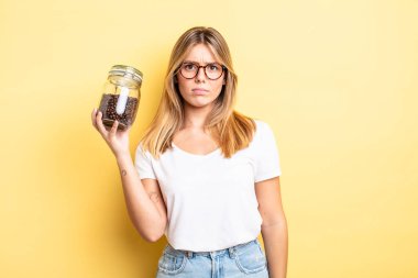 Güzel sarışın kız şaşkın ve şaşkın hissediyor. kahve çekirdeği konsepti