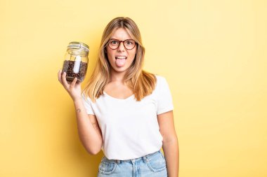 Güzel sarışın kız iğreniyor, sinirleniyor ve dilini çıkarıyor. kahve çekirdeği konsepti