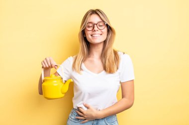 Güzel sarışın kız komik bir şakaya yüksek sesle gülüyor. çaydanlık konsepti