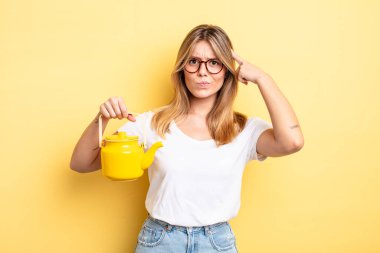 Güzel sarışın kız şaşkın ve şaşkın hissediyor, senin deli olduğunu gösteriyor. çaydanlık konsepti