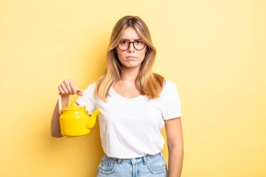 Güzel sarışın kız üzgün, üzgün ya da kızgın ve yana bakıyor. çaydanlık konsepti