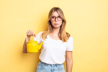 Güzel sarışın kız üzgün ve mızmızlanıyor. Mutsuz bir bakışı var ve ağlıyor. çaydanlık konsepti