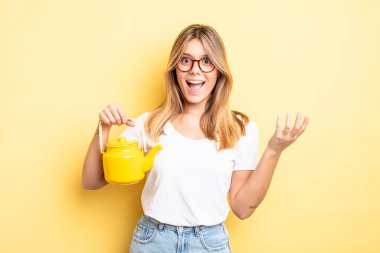 Güzel sarışın kız kendini mutlu hissediyor, bir çözüm ya da fikir bulduğuna şaşırıyor. çaydanlık konsepti