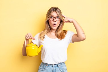 Güzel sarışın kız şaşırmış görünüyor, yeni bir düşünce, fikir ya da konsept fark ediyor. çaydanlık konsepti