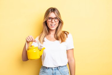 Güzel sarışın kız şaşkın ve şaşkın hissediyor. çaydanlık konsepti