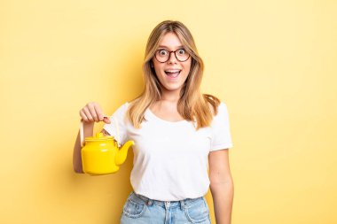 Güzel sarışın kız mutlu ve hoş bir şekilde şaşırmış görünüyor. çaydanlık konsepti