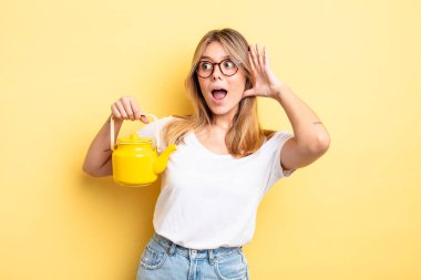 Güzel sarışın kız mutlu, heyecanlı ve şaşırmış hissediyor. çaydanlık konsepti