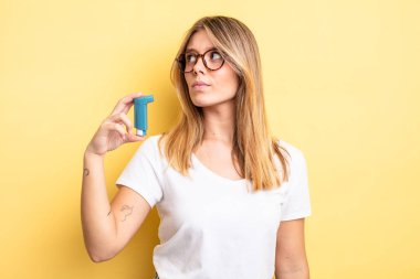 Profil görünümündeki güzel sarışın kız hayal mi kuruyor, hayal mi kuruyor yoksa hayal mi kuruyor? astım spreyi kavramı