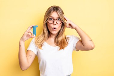 Güzel sarışın kız şaşırmış görünüyor, yeni bir düşünce, fikir ya da konsept fark ediyor. astım spreyi kavramı