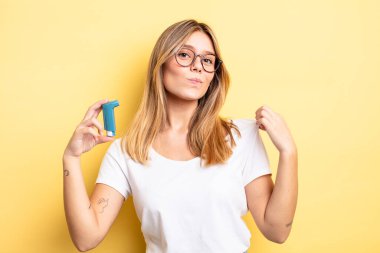 Güzel sarışın kız kibirli, başarılı, pozitif ve gururlu görünüyor. astım spreyi kavramı