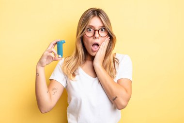 Güzel sarışın kız şok olmuş ve korkmuş hissediyor. astım spreyi kavramı