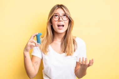 Güzel sarışın kız umutsuz, sinirli ve stresli görünüyor. astım spreyi kavramı