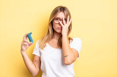 Güzel sarışın kız bıkkın, yorgun ve uykulu hissediyor. astım spreyi kavramı