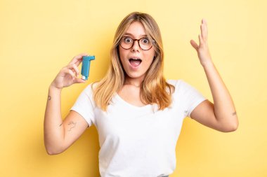 Güzel sarışın kız şok olmuş ve şaşırmış hissediyor. astım spreyi kavramı