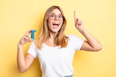 Güzel sarışın kız bir fikri fark ettikten sonra mutlu ve heyecanlı bir dahi gibi hissediyor. astım spreyi kavramı