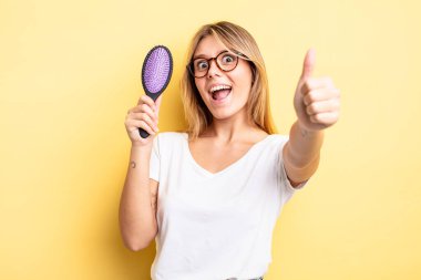 Güzel sarışın kız gururlu, olumlu gülümsüyor. saç fırçası konsepti