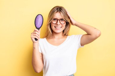 Güzel sarışın kız stresli, endişeli ya da korkmuş, elleri başının üstünde. saç fırçası konsepti