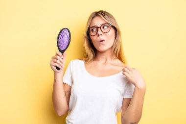 Güzel sarışın kız stresli, endişeli, yorgun ve hayal kırıklığına uğramış hissediyor. saç fırçası konsepti