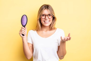 Güzel sarışın kız sinirli, sinirli ve sinirli görünüyor. saç fırçası konsepti