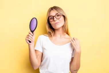 Güzel sarışın kız kibirli, başarılı, pozitif ve gururlu görünüyor. saç fırçası konsepti