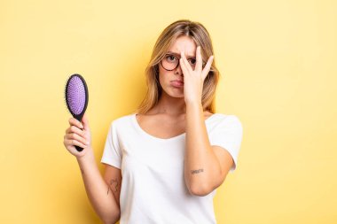 Güzel sarışın kız bıkkın, yorgun ve uykulu hissediyor. saç fırçası konsepti