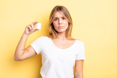 Güzel sarışın kız üzgün, üzgün ya da kızgın ve yana bakıyor. hap şişesi konsepti