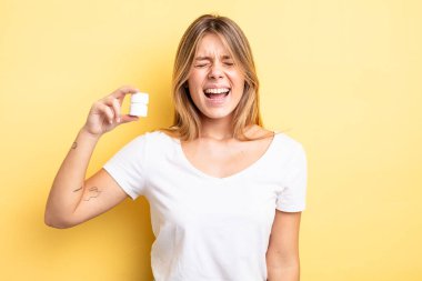 Güzel sarışın kız agresif bir şekilde bağırıyor, çok kızgın görünüyor. hap şişesi konsepti