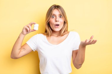 Güzel sarışın kız inanılmaz bir sürprizle şaşkına döndü ve hayrete düştü. hap şişesi konsepti