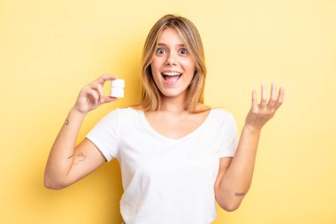 Güzel sarışın kız kendini mutlu hissediyor, bir çözüm ya da fikir bulduğuna şaşırıyor. hap şişesi konsepti