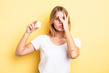 Güzel sarışın kız bıkkın, yorgun ve uykulu hissediyor. hap şişesi konsepti