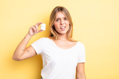 Güzel sarışın kız şaşkın ve şaşkın hissediyor. hap şişesi konsepti